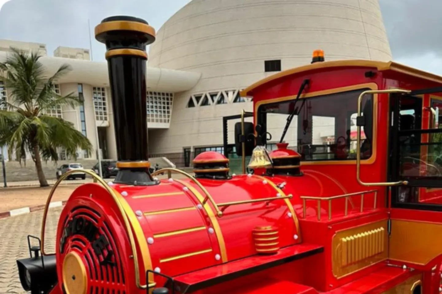 Le Petit Train de Cotonou, locomotive rouge stationnée devant la Fondation Zinsou